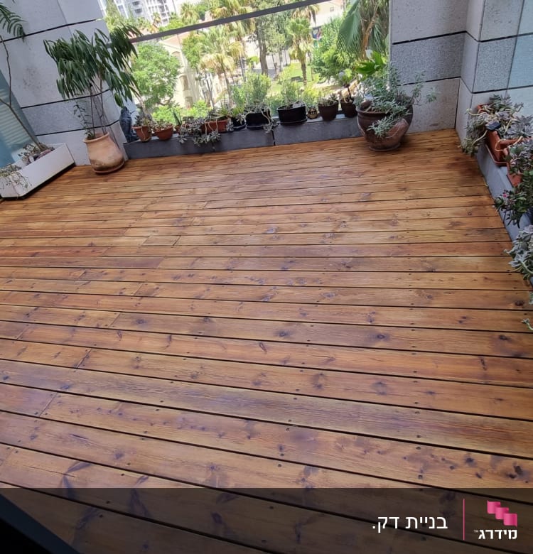 רצפת עץ עם עציצים מסביב במרפסת